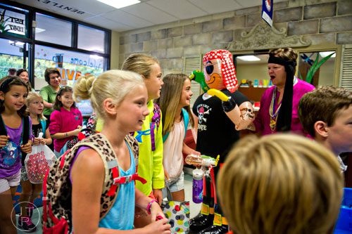 Principal Dr. Dee Mobley (right) greets Maggie Lee, Hampton Gucky, her sister Teller and other students as they pass by during the first day of classes at Davis Elementary School in Marietta on Monday, August 4, 2014. 