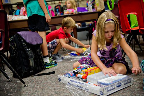 Kaylah Hester (right) and Tyler Crump open their supplies during the first day of classes at Davis Elementary School in Marietta on Monday, August 4, 2014. 