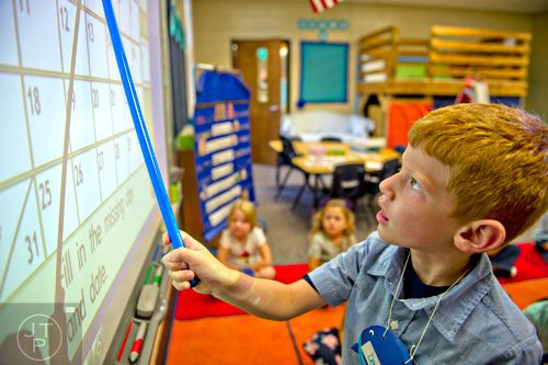Deacon Pederson uses a smart board during the first day of classes at Davis Elementary School in Marietta on Monday, August 4, 2014. 