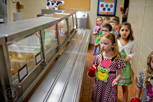 Alison MacDonald (right) walks through the cafeteria on a scavenger hunt tour of Davis Elementary School in Marietta on Monday, August 4, 2014.