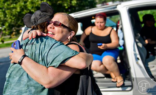 Wanda Oliveras (center) hugs Ty Esham as her family arrives at Esham's office in Decatur on Tuesday, August 5, 2014. 