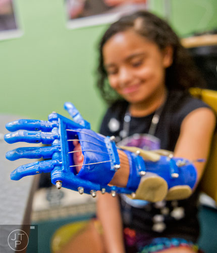 10-year-old Anastasia Rivas tries out her new robohand assistive device in Ty Esham's office in Decatur on Tuesday, August 5, 2014.  