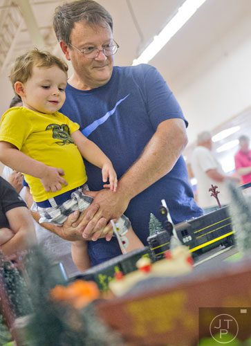 Steven Niehenke (left) is held by his grandfather Ryan Riley as they watch model trains pass by during the 47th Atlanta Model Train and Railroadiana Show and Sale at the North Atlanta Trade Center in Norcross on Saturday, August 9, 2014.