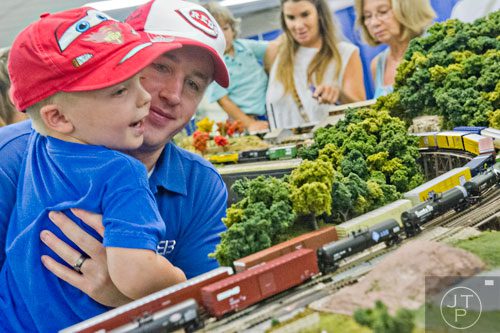 Joshua Palmer (center) holds his son Gabriel as they watch model trains pass by during the 47th Atlanta Model Train and Railroadiana Show and Sale at the North Atlanta Trade Center in Norcross on Saturday, August 9, 2014. 