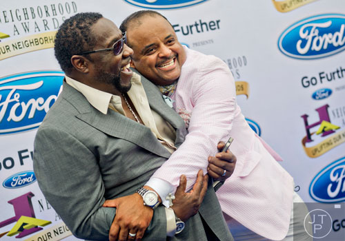 Lead singer of the O'Jays Eddie Levert (left) is hugged by Roland Martin as they pose for photos on the blue carpet before the 2014 Ford Neighborhood Awards at Philips Arena in Atlanta on Saturday, August 9, 2014. 