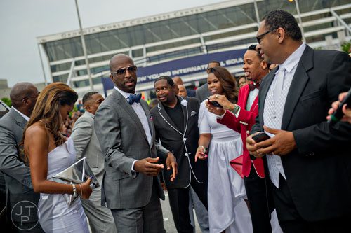 Rickey Smiley (center) heads towards the blue carpet before the 2014 Ford Neighborhood Awards at Philips Arena in Atlanta on Saturday, August 9, 2014.