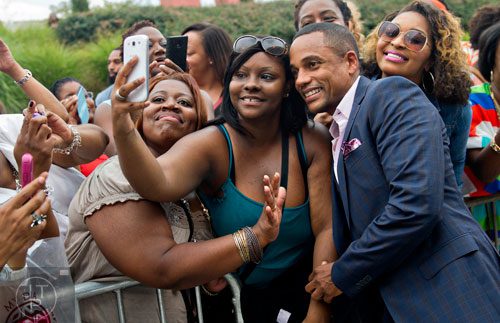 Hill Harper (center) poses for a photo with fans Caprice Wilder (left), Erica Jones and Terea Smith before the 2014 Ford Neighborhood Awards at Philips Arena in Atlanta on Saturday, August 9, 2014.