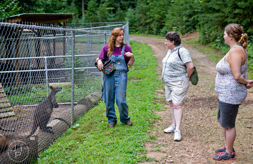 Shannon Kelly (left) tells Barbara Hamm and her daughter Monica about the wallaby standing next to her and other marsupials during a tour at the North Georgia Zoo and Petting Farm in Cleveland on Sunday, August 10, 2014. 
