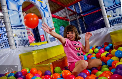 Rachel Misrahi (center) throws a plastic ball into the air as she plays in the three story space tower at Catch Air in Johns Creek on Thursday, August 14, 2014. 