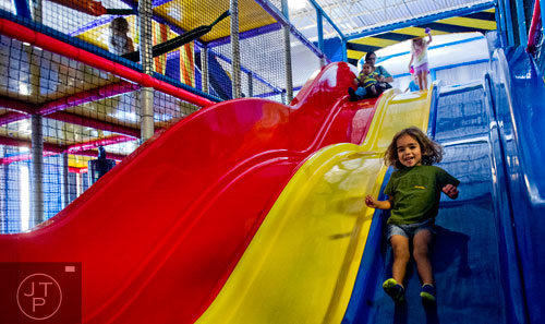 Franco Blancas (right) zooms down a triple slide in the three story space tower at Catch Air in Johns Creek on Thursday, August 14, 2014.  