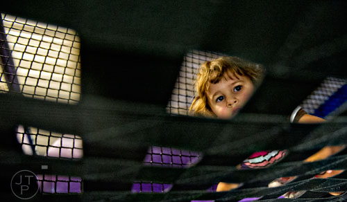 Ava Wright climbs over obstacles in the three story space tower at Catch Air in Johns Creek on Thursday, August 14, 2014.  