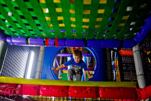 Lucas Deal climbs over obstacles in the three story space tower at Catch Air in Johns Creek on Thursday, August 14, 2014. 
