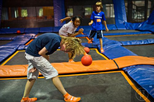 Hugo Mulligan (left) tries to dodge being hit by Amiya Hunt and his brother Kyle while playing a game of dodgeball at Sky Zone indoor trampoline park in Suwanee on Friday, August 15, 2014.  