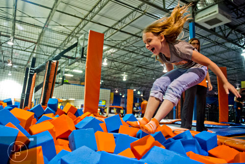 Sophia Caveney flies into a foam pit at Sky Zone indoor trampoline park in Suwanee on Friday, August 15, 2014.   