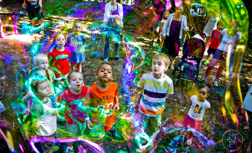Noah Mims (right), Brayden Watt, Evan Nadler and other children try to keep a bubble in the air by blowing on it during the Butterfly Festival at the Dunwoody Nature Center on Saturday, August 16, 2014. 