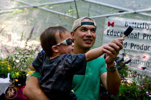 Harris Lee (left) reaches for a butterfly with the help of his father David during the Butterfly Festival at the Dunwoody Nature Center on Saturday, August 16, 2014. 