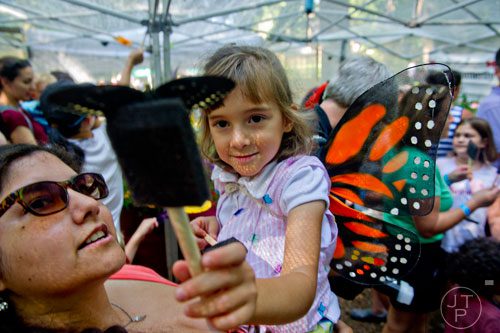 Alex Deupree (right) takes a close look at a butterfly as she is held by her mother Laura during the Butterfly Festival at the Dunwoody Nature Center on Saturday, August 16, 2014. 