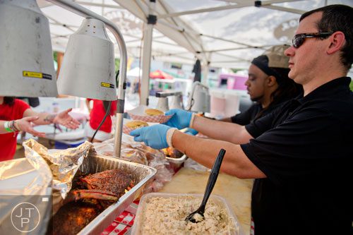 Scott Carlyle fills orders for barbeque during the Decatur BBQ, Blues & Bluegrass Festival at Harmony Park in Decatur on Saturday, August 16, 2014. 