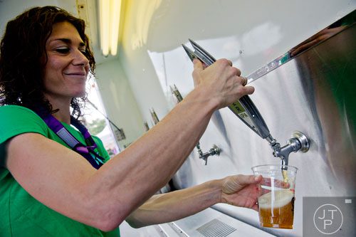 Blair Rostolsky pours a beer during the Decatur BBQ, Blues & Bluegrass Festival at Harmony Park in Decatur on Saturday, August 16, 2014. 