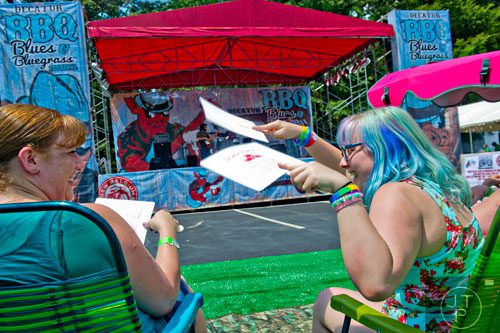 Candice Darling (left) is fanned by her daughter Ayralynn as the listen to The Georgia Flood perform during the Decatur BBQ, Blues & Bluegrass Festival at Harmony Park in Decatur on Saturday, August 16, 2014.