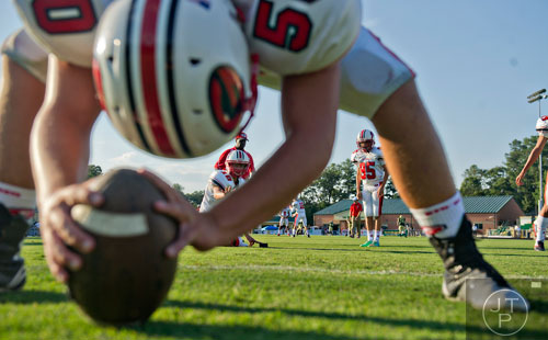 Gainesville's Brandon Reyna (95) and Andy Hayes (10) wait on a hike from Bill Hood (front) as they warm up before their game against Grayson on Friday, August 29, 2014.   