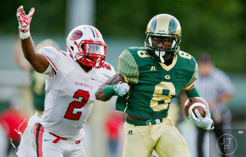 Grayson's Cedric Asseh (8) moves the ball towards the end zone as he is chased by Gainesville's Chris Byrd (2) on Friday, August 29, 2014. 