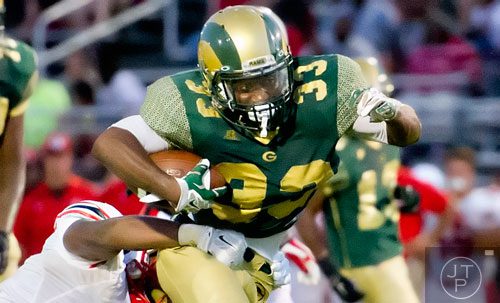 Grayson's Cameryn Brent (33) moves the ball towards the end zone as he is tackled by Gainesville's Jadarius Sosebee (left) on Friday, August 29, 2014. 