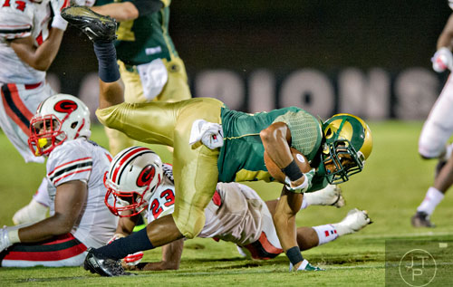 Grayson's Deshaun Warren (right) tries to keep on his feet as he is tackled by Gainesville's Toddrick Turner (23) on Friday, August 29, 2014. 