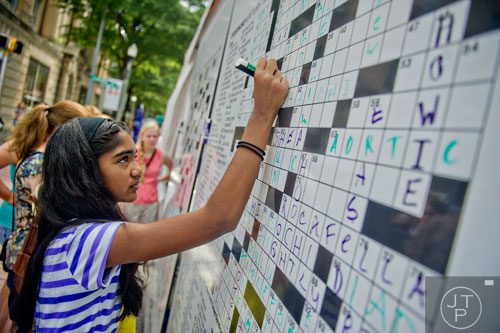 Smruthi Balasubramaniam (left) fills in the answer to a giant crossword puzzle during the AJC Decatur Book Festival on Saturday, August 30, 2014. 