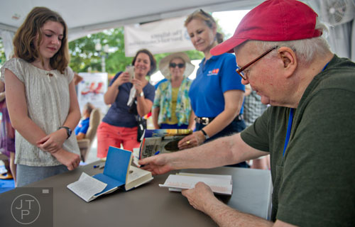 Author Pat Conroy (right) signs a book for Sophie Peck as her mother Brigitte takes a photo with her phone during the AJC Decatur Book Festival on Saturday, August 30, 2014. 