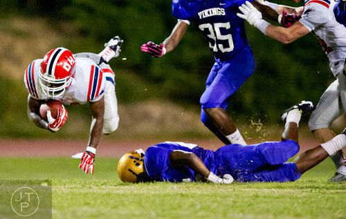 Dunwoody's Devin Francois (left) flies through the air after being tripped up by Lakeside-Dekalb's Javarus Wesley (right) on Friday, September 19, 2014.