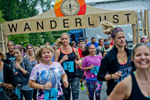 Ash Akley (center) takes off from the starting line during the 5k portion of Wanderlust 108 at Piedmont Park in Atlanta on Sunday, September 28, 2014.