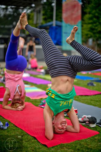 Brook Machin (right) and Dana Blair practice their yoga poses as they wait for the meditation portion of the event to begin during Wanderlust 108 at Piedmont Park in Atlanta on Sunday, September 28, 2014. 