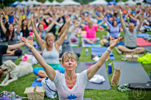 Kim Ebetino (center) stretches her hands towards the sky during the yoga portion of Wanderlust 108 at Piedmont Park in Atlanta on Sunday, September 28, 2014. 
