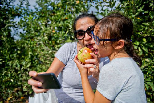 Cecilia Venable (left) and her daughter Annabella take a selfie as they pretend to eat an apple at Mercier Orchards in Blue Ridge on Sunday, September 14, 2014.  
