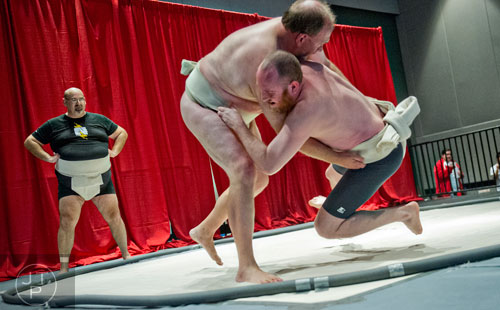 Scott Witt (right) is thrown from the ring by Packy Bannevans as Michael Gokey waits for his turn to compete in the sumo wrestling demonstration during the 2014 JapanFest at the Gwinnett Center in Duluth on Saturday, September 20, 2014. 