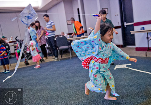 Chihiro Tanaka runs with her newly built kite during the 2014 JapanFest at the Gwinnett Center in Duluth on Saturday, September 20, 2014. 