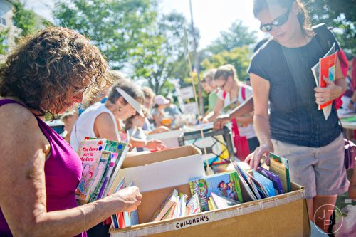 Lisa Goldman (left) and Mary Lynn Gaines (right) look through boxes of children's books during the AJC Decatur Book Festival on Saturday, August 30, 2014. 