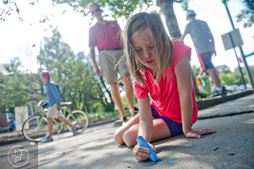Lindsay Tewell writes a poem on the sidewalk using chalk during the AJC Decatur Book Festival on Saturday, August 30, 2014.