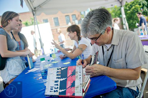 Len Vlahos (right) signs copies of his book during the AJC Decatur Book Festival on Saturday, August 30, 2014.