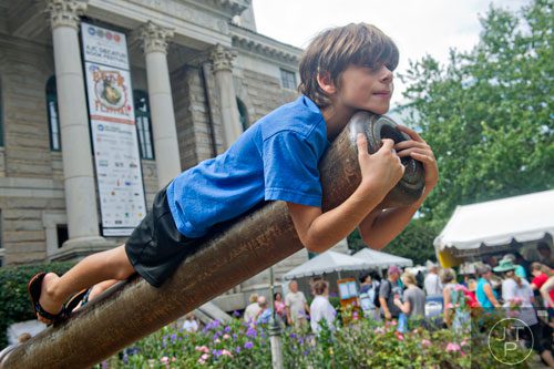 Diogo Richards hangs out on the barrel of the cannon outside of the historic courthouse during the AJC Decatur Book Festival on Saturday, August 30, 2014.