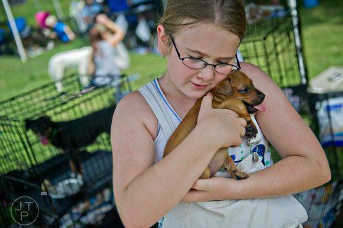 Sabrina Lachance holds a chihuahua mix in her arms during the Dog Days of Summer event outside of Park Tavern at Piedmont Park in Atlanta on Saturday, August 30, 2014. 
