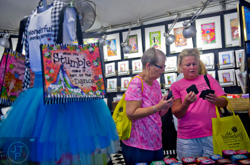 Connie Bailey (left) and Joyce Bagley try to decide which coasters and magnets to buy during the 46th annual Yellow Daisy Festival at Stone Mountain Park on Saturday, September 6, 2014. 