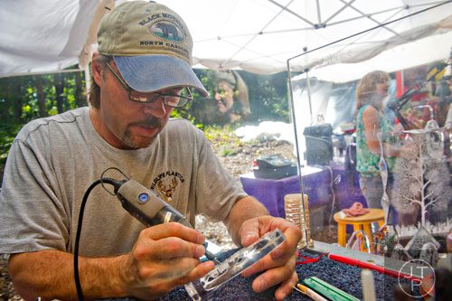 Don Harding etches names into one of his pieces of artwork during the 46th annual Yellow Daisy Festival at Stone Mountain Park on Saturday, September 6, 2014. 