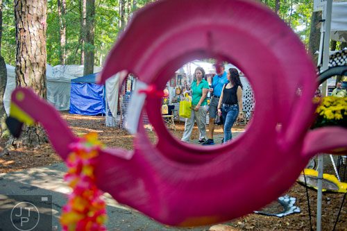 Edelys Betancourt (left) walks with her husband Andy and daughter Ashley as they check out the artist booths during the 46th annual Yellow Daisy Festival at Stone Mountain Park on Saturday, September 6, 2014. 