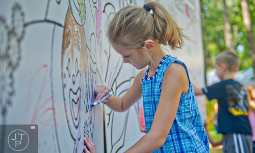 Isabell Sapp (left) colors a giant picture wall inside the children's area during the 46th annual Yellow Daisy Festival at Stone Mountain Park on Saturday, September 6, 2014.