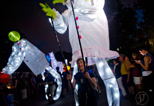 Joy Ayer (right) and her husband Cameron carry lanterns on their backs during the Atlanta Beltline Lantern Parade on Saturday, September 6, 2014.