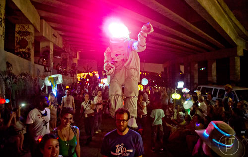 Kiera Robbins (center left) and Thomas Trinh (center right) help operate a giant astronaut during the Atlanta Beltline Lantern Parade on Saturday, September 6, 2014. 