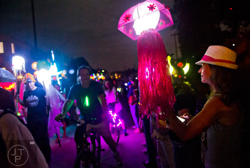 Cameron Zentz (right) holds a light up doll head as she watches while the Atlanta Beltline Lantern Parade passes by on Saturday, September 6, 2014. 