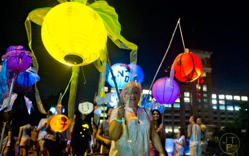 Cathy Pirtle carries a lantern past City Hall East during the Atlanta Beltline Lantern Parade on Saturday, September 6, 2014. 